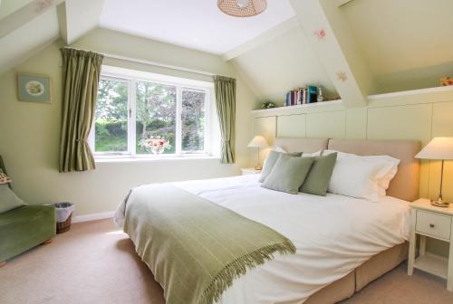 Un dormitorio con una gran cama blanca y una ventana en Stay at Penny's Mill, en Frome