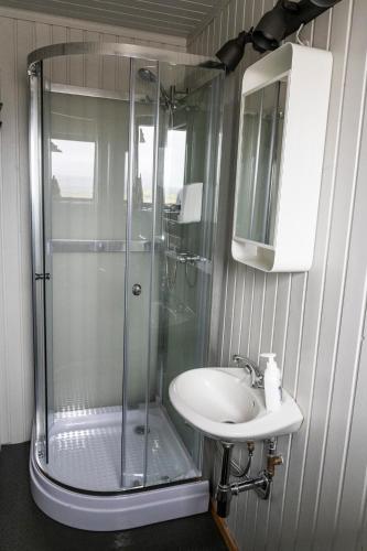 ein Badezimmer mit Dusche und Waschbecken in der Unterkunft Black Beach Cottage in Þorlákshöfn