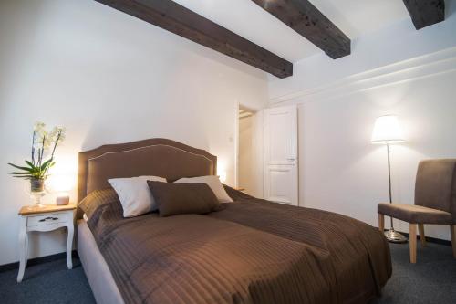 a bedroom with a large bed and a chair at Piernikowy Domek in Toruń