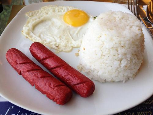 ein Teller mit Reis und einem Ei und zwei Würstchen in der Unterkunft A's Azotea de Bohol in Tagbilaran