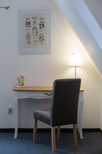 a desk with a chair next to a desk with a lamp at Piernikowy Domek in Toruń