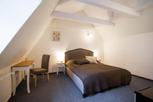 a bedroom with a bed and a desk and a chair at Piernikowy Domek in Toruń
