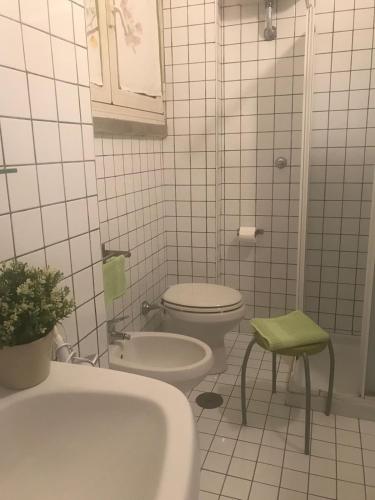 a white bathroom with a toilet and a sink at B&B La Corte in SantʼAntimo