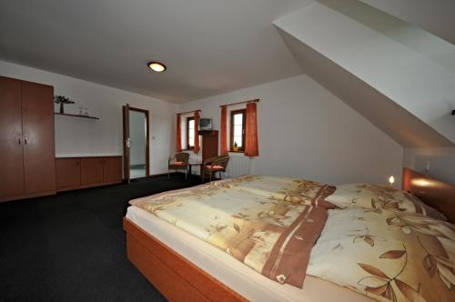 Penzion Praktik Krumlov في Přísečná: غرفة نوم بسرير كبير في العلية