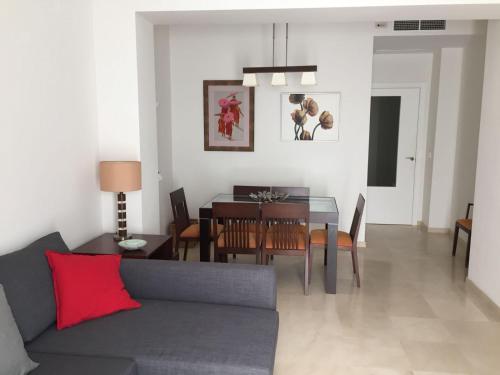 a living room with a couch and a dining room table at Apartamento centro Sevilla in Seville