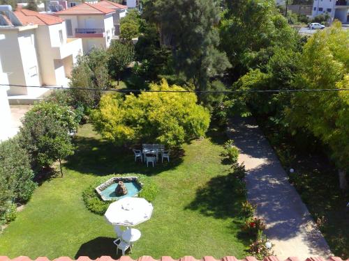 an overhead view of a garden with a woman sitting in the grass at Alexia Apartments & Studios in Kremasti