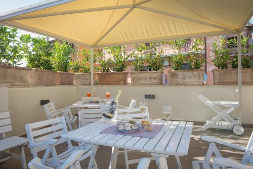 a white table and chairs with a yellow umbrella at Malì Trevignano Piccolo Hotel in Trevignano Romano