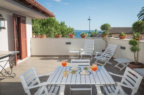 a white table and chairs on a patio at Malì Trevignano Piccolo Hotel in Trevignano Romano