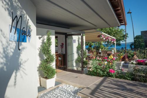 uma casa com um pátio com flores e plantas em Malì Trevignano Piccolo Hotel em Trevignano Romano