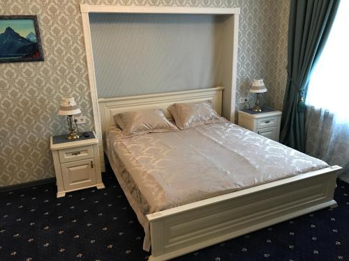 ein Schlafzimmer mit einem großen Bett mit zwei Nachttischen in der Unterkunft Happy Cat in Odessa