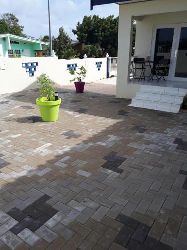 a patio with two potted plants in front of a house at The Lush in Willemstad
