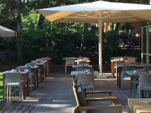 Hotel Parco في ميلانو ماريتيما: صف من الطاولات والكراسي مع مظلة