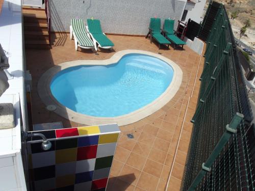 una piscina con dos sillas y una valla en Lancelot, en Puerto Rico de Gran Canaria