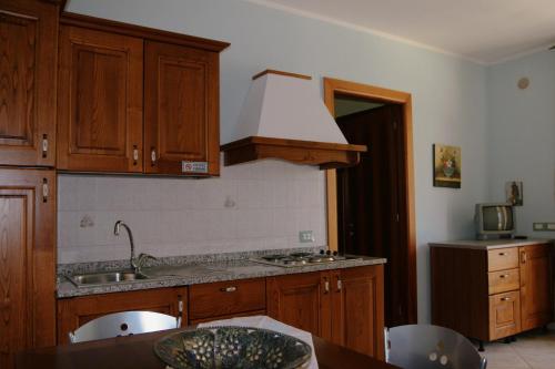 eine Küche mit Holzschränken und einem Waschbecken in der Unterkunft Le Terre Di Toscana in Casa Pallini