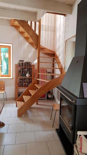- un salon avec un escalier en bois dans une maison dans l'établissement Gite Le Moulin de Rosieres Moulin Champetier, à Rosières
