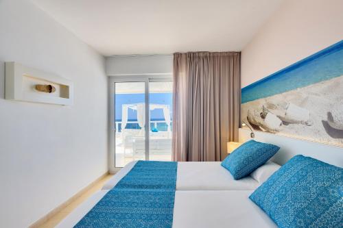 a hotel room with a bed and a large window at Aparthotel Tropic Garden in Santa Eularia des Riu