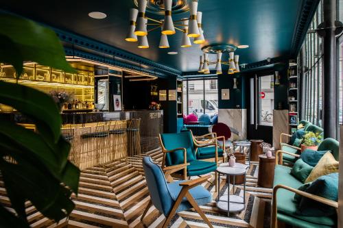 restauracja z niebieskimi krzesłami i barem w obiekcie Rose Bourbon w Paryżu