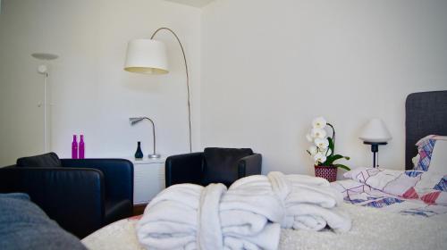 a room with a pile of towels on a bed at In Swiss Home - Barfüsserplatz BAR street Apartment in Basel