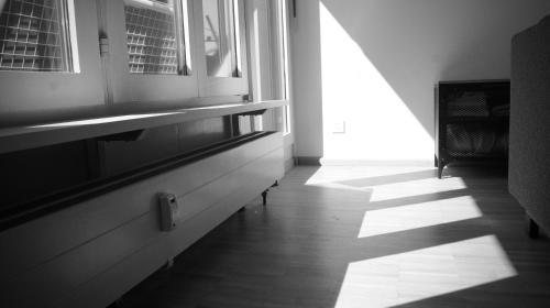 a hallway with a window and a sun shining through at In Swiss Home - Barfüsserplatz BAR street Apartment in Basel