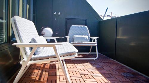 two chairs and a table on a balcony at In Swiss Home - Barfüsserplatz BAR street Apartment in Basel