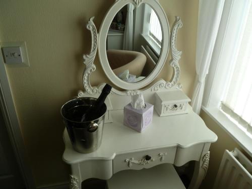 a white dressing table with a mirror on it at Greenlaw Guest House in Gretna Green
