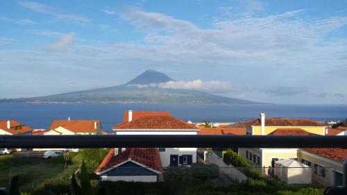 a view of a mountain in the ocean with houses at Vista do Canal Plus in Horta