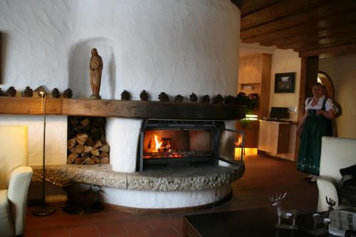 a woman standing in a living room with a fireplace at Hotel Schloss Berg in Berg am Starnberger See