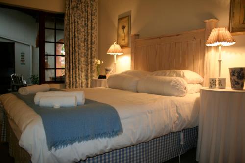 sypialnia z dużym białym łóżkiem i niebieskim kocem w obiekcie Die Kersiehuis w mieście Ficksburg