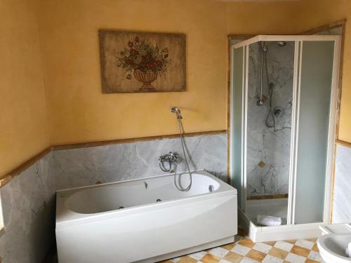 a white tub in a bathroom with a shower at Villa Sant’Andrea in Siena