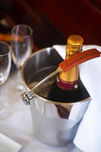 a bottle of champagne in a bucket on a table at Leeds Castle Stable Courtyard Bed and Breakfast in Maidstone