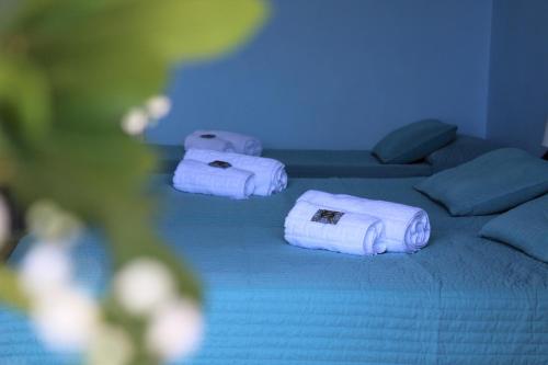 2 Handtücher auf einem Bett in einem blauen Zimmer in der Unterkunft Nireus Hotel in Nea Makri
