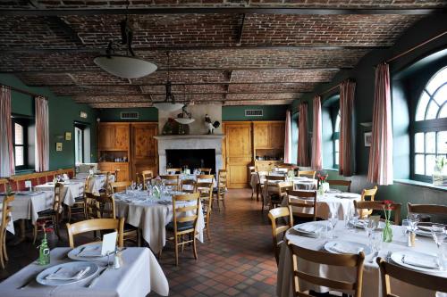 une salle à manger avec tables et chaises et une cheminée dans l'établissement Best Western La Metairie, à Gosnay