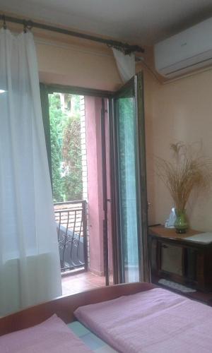 a bedroom with a bed and a sliding glass door at Smeštaj - sobe MARVEL in Niš