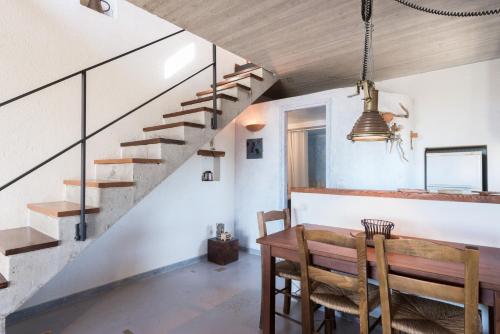 a dining room with a wooden table and stairs at Red Art Maisonette in Kardhakáta