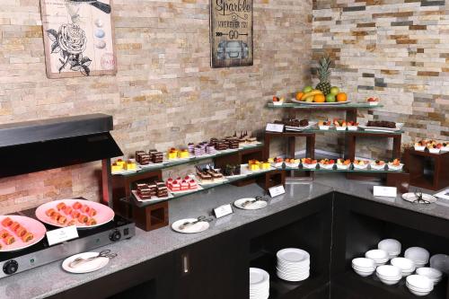 a kitchen with a bunch of food on display at Park Regis Lotus Hotel in Manama