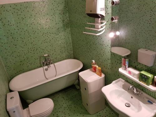 a bathroom with a tub and a toilet and a sink at Vintage Vieux-Port Apartment in Marseille