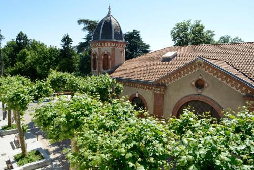 a building with a tower and a roof with trees at Hôtel Brasserie du Parc in Albi