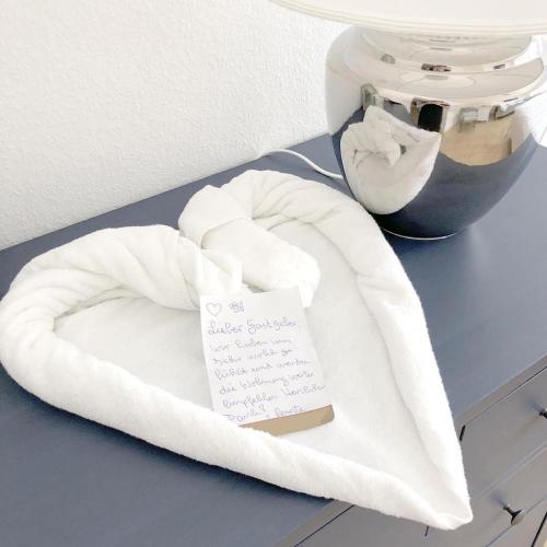 a white towel on a counter with a sign on it at F10 APARTMENTS Ulm in Ulm