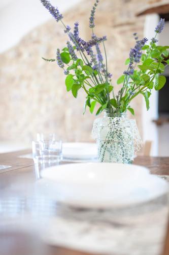 a vase filled with purple flowers sitting on a table at Agriturismo Casa Vecchia in Morcella