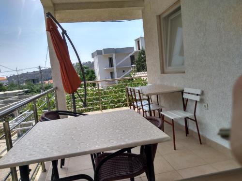 a balcony with tables and chairs and an umbrella at Apartment Djokic in Sutomore
