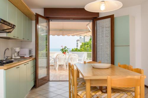 uma cozinha e sala de jantar com uma mesa e vista para o oceano em Appartamenti Lignano Sabbiadoro - Villa Ammiraglia em Lignano Sabbiadoro