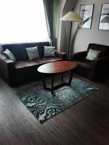 a living room with a couch and a coffee table at Akzent Hotel Köhler in Gießen
