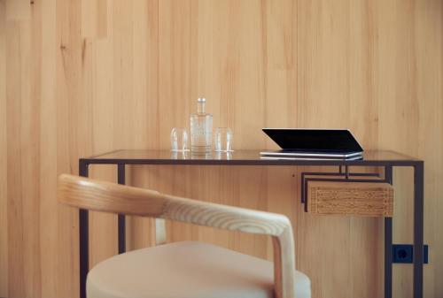 a wooden table with a laptop and a chair at Hotel Jakarta Amsterdam in Amsterdam