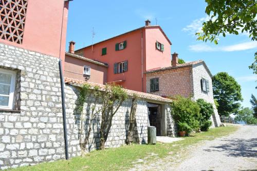 eine Außenansicht eines Gebäudes mit einer Steinmauer in der Unterkunft Agriturismo Monte Pu' in Castiglione Chiavarese