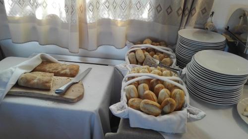 a table topped with baskets of bread and plates at Hotel Aldiola Country Resort in Sant Antonio Di Gallura