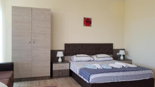 a bedroom with a large bed with two pillows at Brilliant Aparthotel in Sozopol