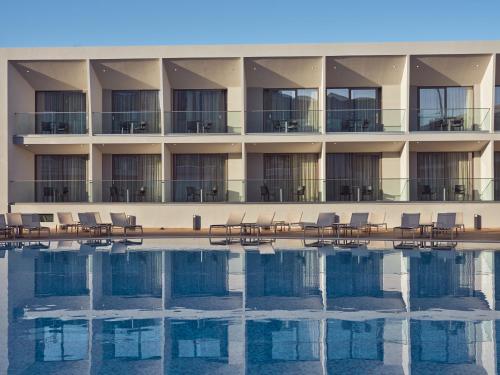 a hotel with chairs and a swimming pool at Zante Sun Resort in Lithakia