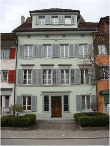 a large white house with a door and windows at Executive suite in Zug Old Town Triplex in Zug