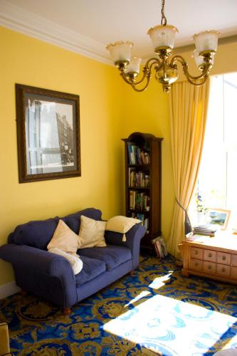 a living room with a blue couch and a window at 17 Wilmington Square in Eastbourne