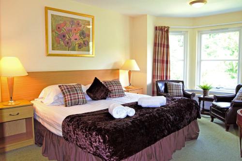 a bedroom with a bed with two towels on it at Bridge of Cally Hotel in Blairgowrie